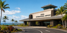 Kona International Airport entrance with palm trees and a coastal Big Island backdrop