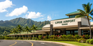 Lihue Airport terminal with tropical landscaping and Kauai mountains